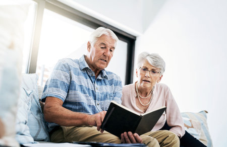 What do our financial habits add up to. a senior couple going through their paperwork together at home.の写真素材