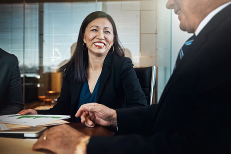 His ideas never fail to impress. two businesspeople talking to one another in the office.の写真素材