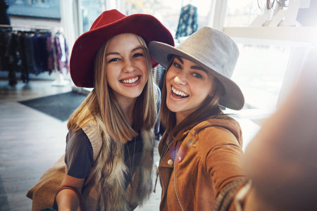 Shopping keeps us smiling. two young girlfriends snapping selfies while out on a shopping spree.の写真素材