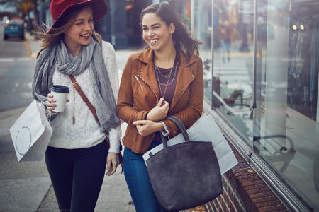Where to next. two young girlfriends walking around downtown while on a shopping spree.の写真素材