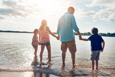 Its the best way to cool off and have some fun. a beautiful family spending some quality time on the beach.の写真素材
