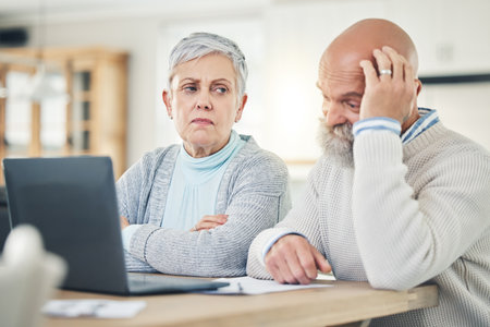 Laptop, stress and budget with a senior couple feeling anxiety about their pension or retirement fund. Computer, debt finance or accounting with old people problem solving their savings or investmentの写真素材