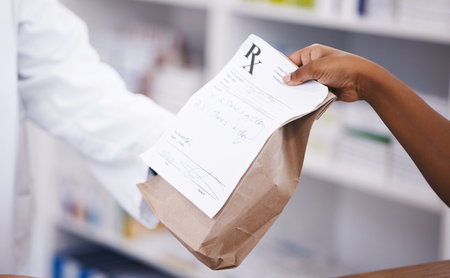 Retail, medicine or pharmacist hands a person a bag in drugstore with healthcare prescription receipt. Zoom, shopping or doctor giving customer product, pills or package for medical pharmacy servicesの写真素材