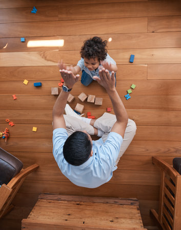 High five, toys and top view of father with baby on floor for playing, educational games and learning. Child development, family and above of happy dad and young boy for celebration, bonding and loveの写真素材