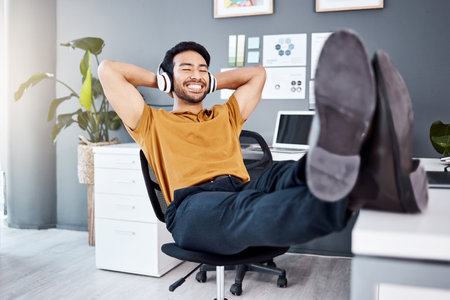 Office music, relax and happy man finished with business work, listening to calm podcast or radio audio sound. Headphones, easy and professional worker, employee or male agent streaming song trackの写真素材