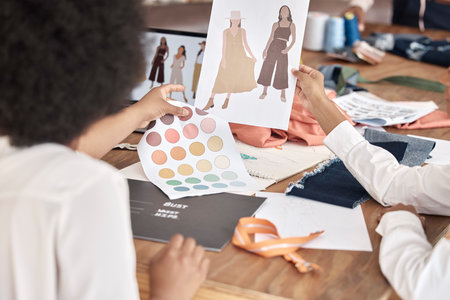 Fashion, designer sketch and team collaboration on project, illustration or paper at a desk in office. Creative women, hands and teamwork on planning, discussion and drawing a design for clothes ideaの写真素材