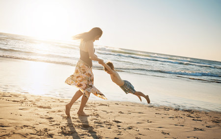They always come up with something fun to do. a young woman spending the day at the beach with her son.の写真素材