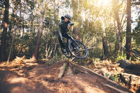 Cycling trick, speed and man on a bicycle on a dirt forest road doing training and exercise on a...