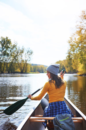 Nothing as calming as a relaxing canoe ride. a young woman going for a canoe ride on the lake.の写真素材