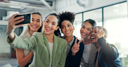 Selfie, friends and business with a black woman group posing for a profile picture together in the office at work. Social media, partnership and teamwork with female colleagues taking a photographの写真素材