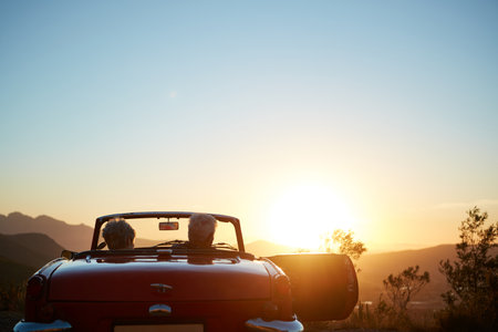 Starting a new chapter titled Adventure. a senior couple enjoying the sunset during a roadtrip.の写真素材