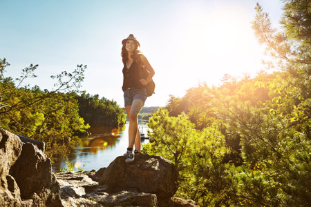 Live in the sunshine and breathe the wild air. a young woman out hiking.の写真素材