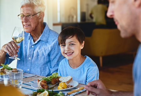 I love spending time with my family. a happy family enjoying lunch together around a table outside.の写真素材
