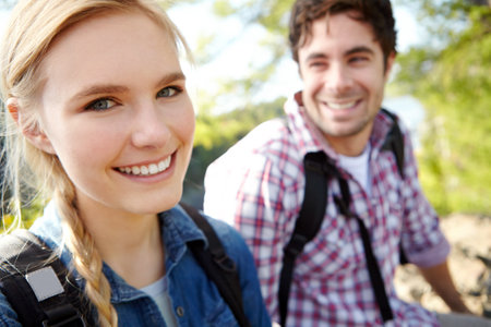 Enjoying nature with a smile. A happy young couple spending time together outdoors in nature.の写真素材