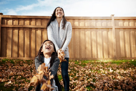 Tons of fun under the autumn sun. an adorable little girl enjoying an autumn day outdoors.の写真素材