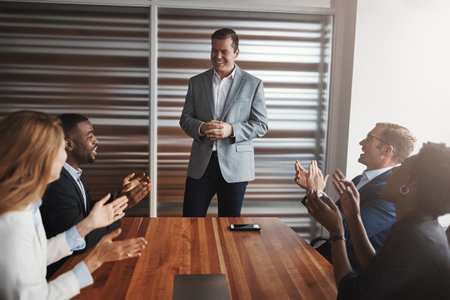 Inspiring the team with his greatness. a group of businesspeople applauding a colleague in an office.の写真素材