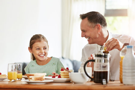 Breakfast is the best with you, Dad. a father and his little daughter having breakfast together at...