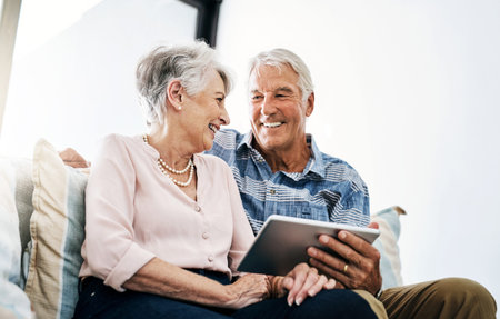 Now thats what I call smart technology. a senior couple relaxing on the sofa and using a digital...