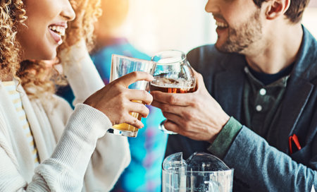 This date only brought us closer. a young couple tinkling their beer glasses together in a pub.の写真素材