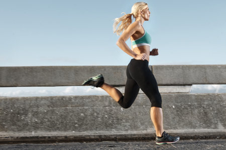 Just me and the streets. Side view of an attractive young woman out for a run.の写真素材