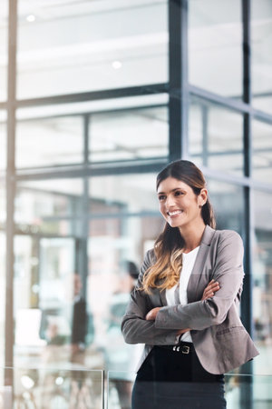 Nothing says success like confidence. a confident young businesswoman working in a modern office.の写真素材