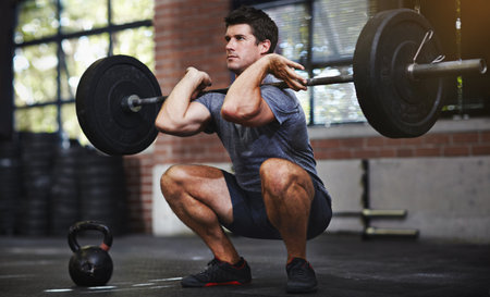 Ready for the lift. a young man lifting weights in a gym.の写真素材