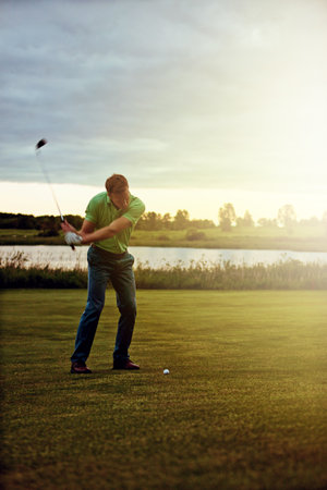 Its all in the form. a man practicing his swing on the golf course.の写真素材
