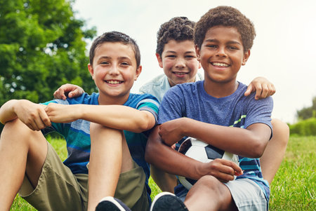 Best mates make the best team mates. a group of young boys out for a game of soccer in the park.の写真素材