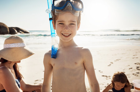Get set to get wet. an adorable little boy wearing snorkelling goggles on a fun day with family at the beach.の写真素材