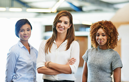 Your trifecta of success. Portrait of a diverse group of young woman standing in an office.の写真素材