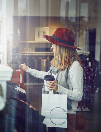 This is something I would wear...a young woman shopping at a clothing store.の写真素材