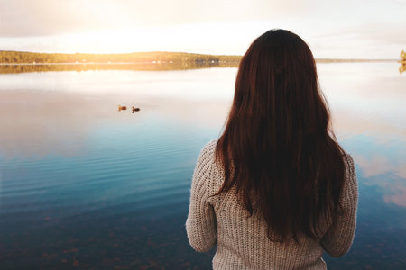 This view is everything. an attractive young woman spending time alone by the lake.の写真素材