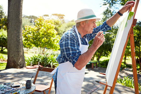 Hes just finishing up. a senior man painting in the park.の写真素材