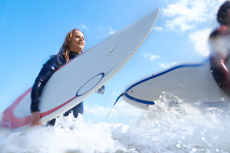 Keep calm and surf on. a young couple out surfing together.の写真素材