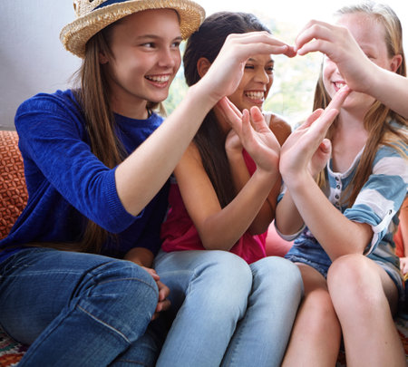 Best friends share the love and the laughter. a group of teenage friends using their hands to make the shape of a heart.の写真素材