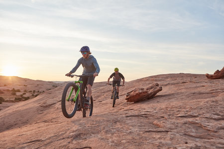 Dont limit your challenges, challenge your limits. Full length shot of two young male athletes mountain biking in the wilderness.の写真素材