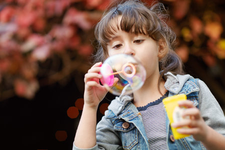 Having bubble fun. a little girl blowing bubbles outdoors.