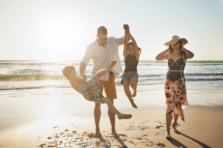 The beach is fun for everyone. a family of four spending the day at the beach.の写真素材