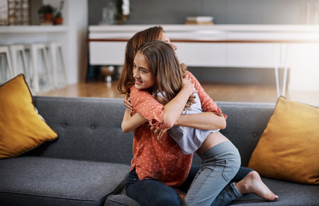 Show her some love. an attractive young woman and her daughter hugging while spending time together at home.の写真素材