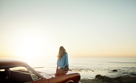 Its the kind of view you can never get tired of. a young woman enjoying a road trip along the coast.の写真素材