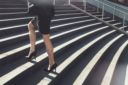 The ambitious never stop climbing. a businesswoman walking up urban steps.の写真素材
