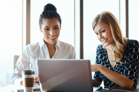 I like what you did here. two attractive young businesswomen working in a modern office.の写真素材