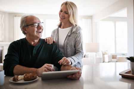 Planning the day the digital way. a mature woman using a digital tablet during a relaxed morning at...