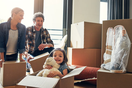 How did she get in the box again. Portrait of a cheerful loving family packing out boxes together in...