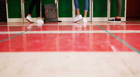 So this is what an ant sees all the time. Low angle shot of a group of unrecognizable students shoes with them standing and waiting to go to class.の写真素材