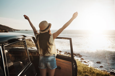 Life, inspired by nature. a young woman enjoying a road trip along the coast.の写真素材