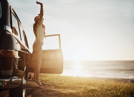 Having the time of her life. a young woman enjoying a road trip along the coast.