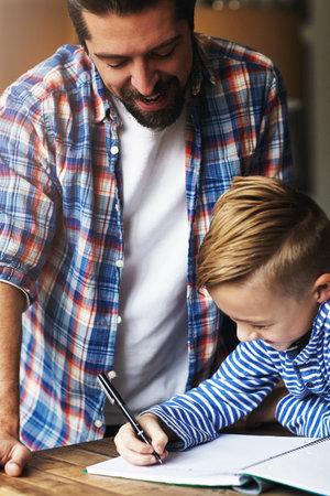 The most important thing for a kids success is their happiness. a father helping his little son with...