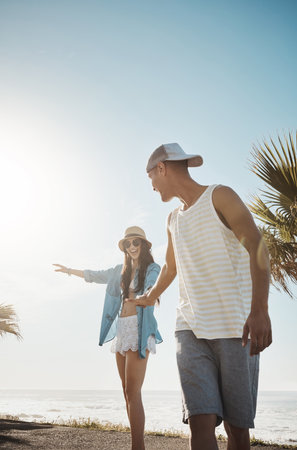 Skating is going to become my new hobby. a young man teaching his girlfriend how to skateboard on the promenade.の写真素材