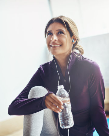 Water is the best nutrient during your workout. an attractive young woman drinking water while...